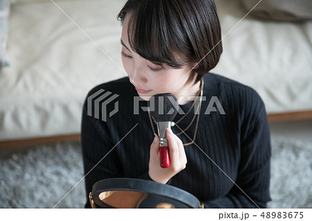 ブラシでチークを塗る若い日本人女性 ブラシでチークを塗る若い日本人女性 48983675