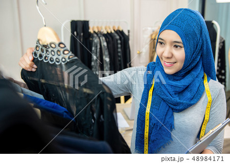 Asian muslim woman designer in her tailor shop Asian muslim woman designer in her tailor shop 48984171