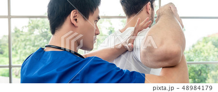 Asian physical therapist stretching athlete male 48984179