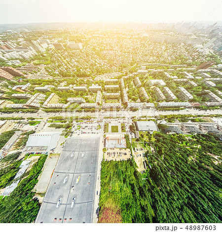 Aerial city view with crossroads and roads, houses, buildings, parks and parking lots. Sunny summer Aerial city view with crossroads and roads, houses, buildings, parks and parking lots. Sunny summer 48987603