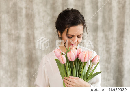 beautiful brunette woman with a bouquet of tulips flowers 48989329
