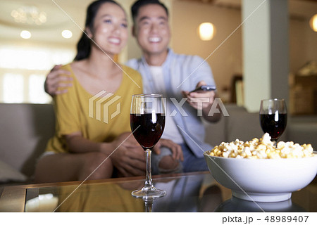 Happy couple watching movie at home Happy couple watching movie at home 48989407