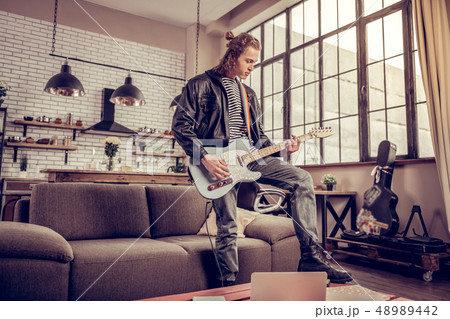 Participant of rock band having rehearsal in the living room 48989442