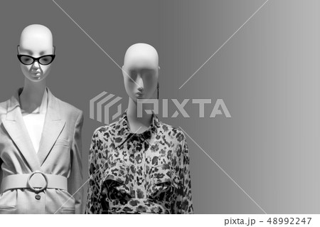 Female mannequins standing in store window display of women casual clothing shop in shopping mall 48992247