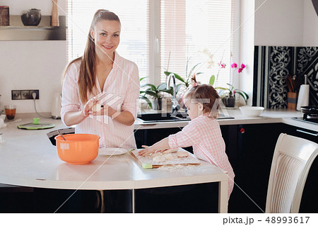 Little lovely kid helping parent with dough at 48993617