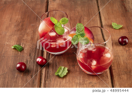 A photo of vibrant red drinks with cherries on a rustic background with copy space A photo of vibrant red drinks with cherries on a rustic background with copy space 48995444