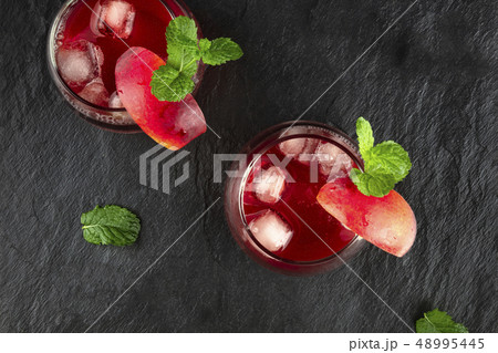 Overhead photo of vibrant red drinks with mint on black Overhead photo of vibrant red drinks with mint on black 48995445