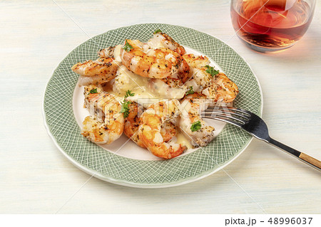 A photo of plate of cooked shrimps on a light background, with a glass of rose wine A photo of plate of cooked shrimps on a light background, with a glass of rose wine 48996037