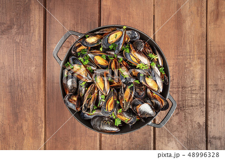 Skillet of marinara mussels on rustic background, overhead shot with copy space 48996328