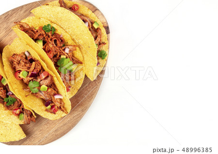 Overhead closeup photo of Mexican tacos with pulled pork, avocado, chili peppers, cilantro, with 48996385