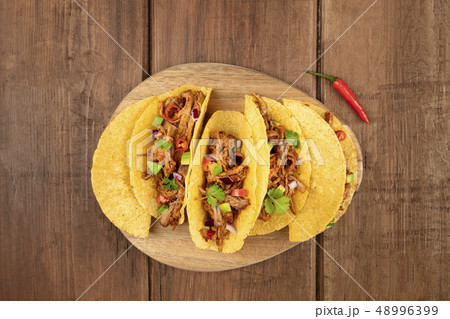 Overhead photo of Mexican tacos with pulled meat, avocado, chili peppers, cilantro, with place for 48996399