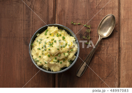 Pomme puree, an overhead photo of a bowl of mashed potatoes with herbs, shot from the top on a Pomme puree, an overhead photo of a bowl of mashed potatoes with herbs, shot from the top on a 48997083