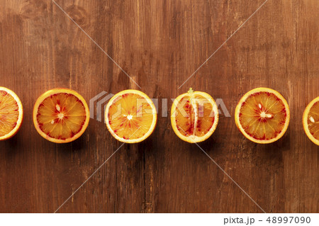 A photo of organic blood oranges, shot from the top on a dark rustic background with a place for 48997090