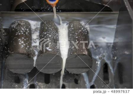 The band saw machine cutting raw metals rods. The band saw machine cutting raw metals rods. 48997637