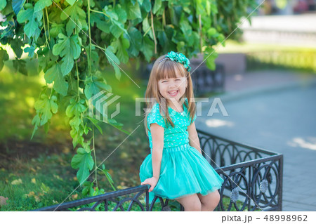 Little girl having fun in city park close to tree 48998962