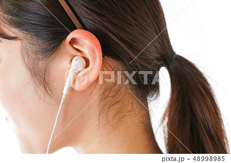 イアフォンで音楽を聞く若い女性 48998985