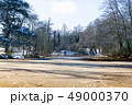 Frozen and snow covered lake surrounded by trees in winter, with a morning sun.  49000370