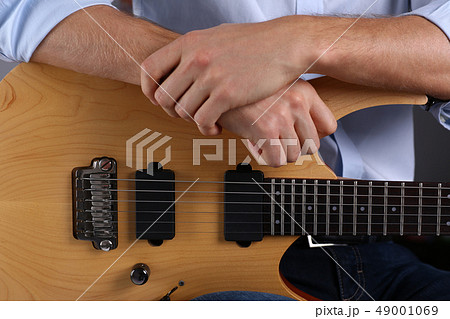 Male arms playing classic shape electric guitar 49001069