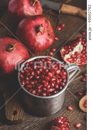 Rustic metal mug full of pomegranate seeds 49002762