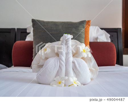 White elephant towel and comfortable pillow on bed 49004487