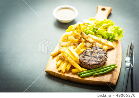 Grilled beef meat steak with french fries sauce and fresh vegetable Grilled beef meat steak with french fries sauce and fresh vegetable 49005570