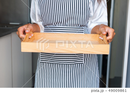 Female hands holding wooden empty tray. Woman 49009861