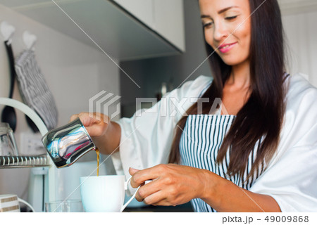 Young happy beautiful brunette woman apron white 49009868