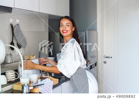 Young happy beautiful brunette woman apron white Young happy beautiful brunette woman apron white 49009892