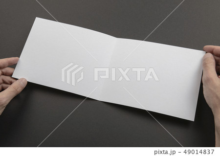 Mens hands holding white booklet 49014837