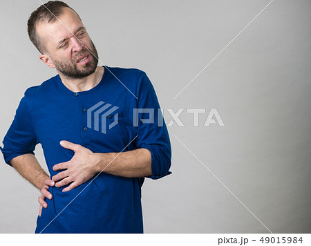 Man having stomach or ribs pain ache. Man having stomach or ribs pain ache. 49015984