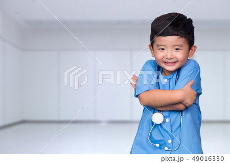 Smiling Asian kid in blue medical uniform holding 49016330