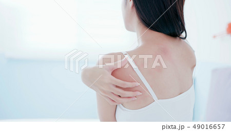 woman scratching shoulder and neck woman scratching shoulder and neck 49016657