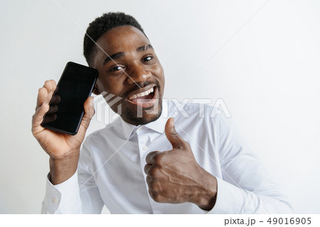 Indoor portrait of attractive young black african man isolated on pink background, holding blank Indoor portrait of attractive young black african man isolated on pink background, holding blank 49016905