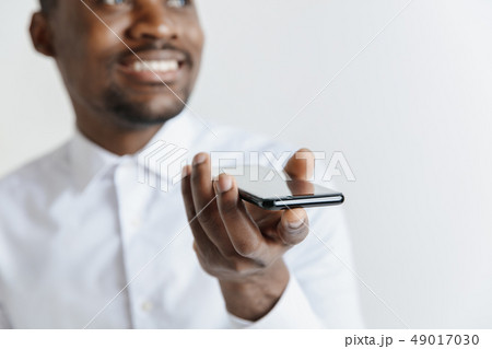 Indoor portrait of attractive young black african man isolated on gray background, holding blank 49017030