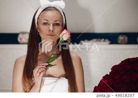 Attractive sensual woman with rose bud smiling at Attractive sensual woman with rose bud smiling at 49018207