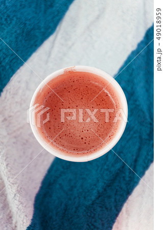 Glass with coffee on a striped beach towel. 49018959