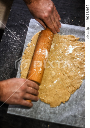 Male hands roll out shortbread gingerbread dough. 49018962