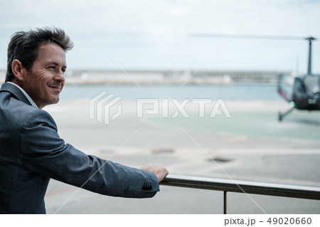 Businessman standing near an airfield Businessman standing near an airfield 49020660