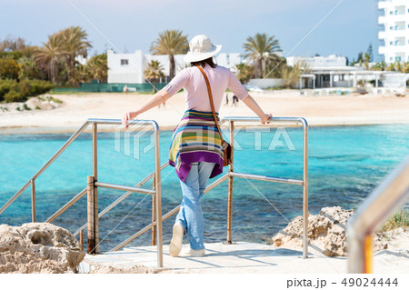 Woman in hat on the beach. Summer holidays, vacation, travel and people concept Woman in hat on the beach. Summer holidays, vacation, travel and people concept 49024444