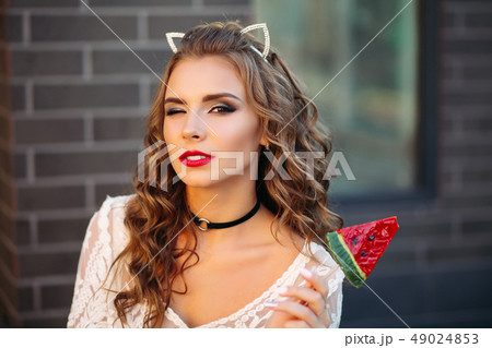 Pretty charming girl like cat with candy in hand. 49024853