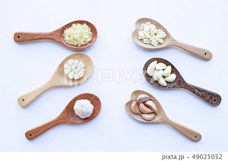 Garlic on wooden spoon on white Garlic on wooden spoon on white 49025052