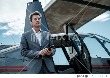 Businessman standing near private helicopter Businessman standing near private helicopter 49025594