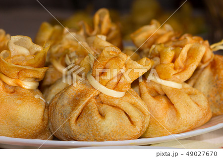 Pancake bags with filling on a plate 49027670