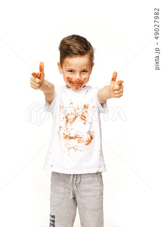 little boy with face and hands in chocolate little boy with face and hands in chocolate 49027982