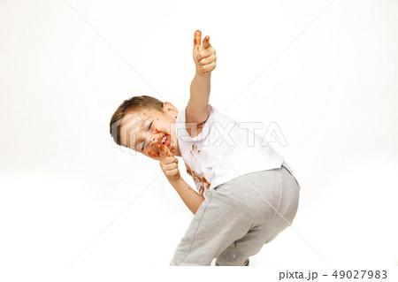 little boy with face and hands in chocolate  49027983
