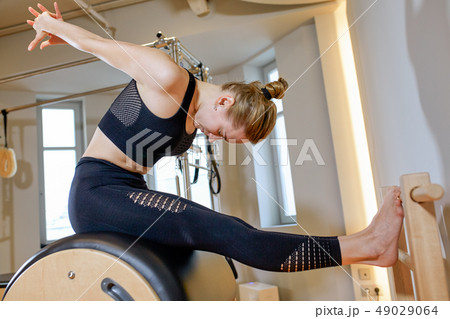 Beautiful girl on the simulator stretches and trains your back, silence gesture 49029064