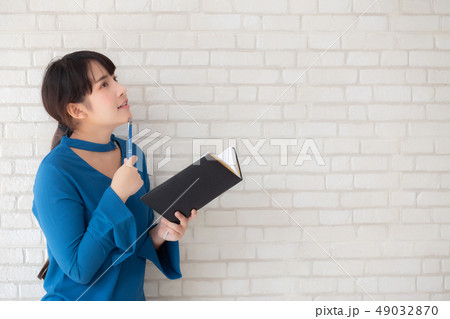 Beautiful asian woman thinking writing notebook 49032870