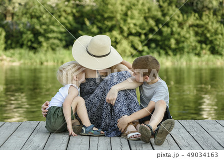 Two little son kissing and hugging her mother 49034163