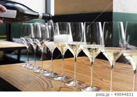 The waiter pours champagne into the glasses The waiter pours champagne into the glasses 49044831
