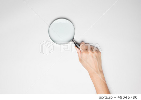 A female hand hold a magnifier isolated in white A female hand hold a magnifier isolated in white 49046780